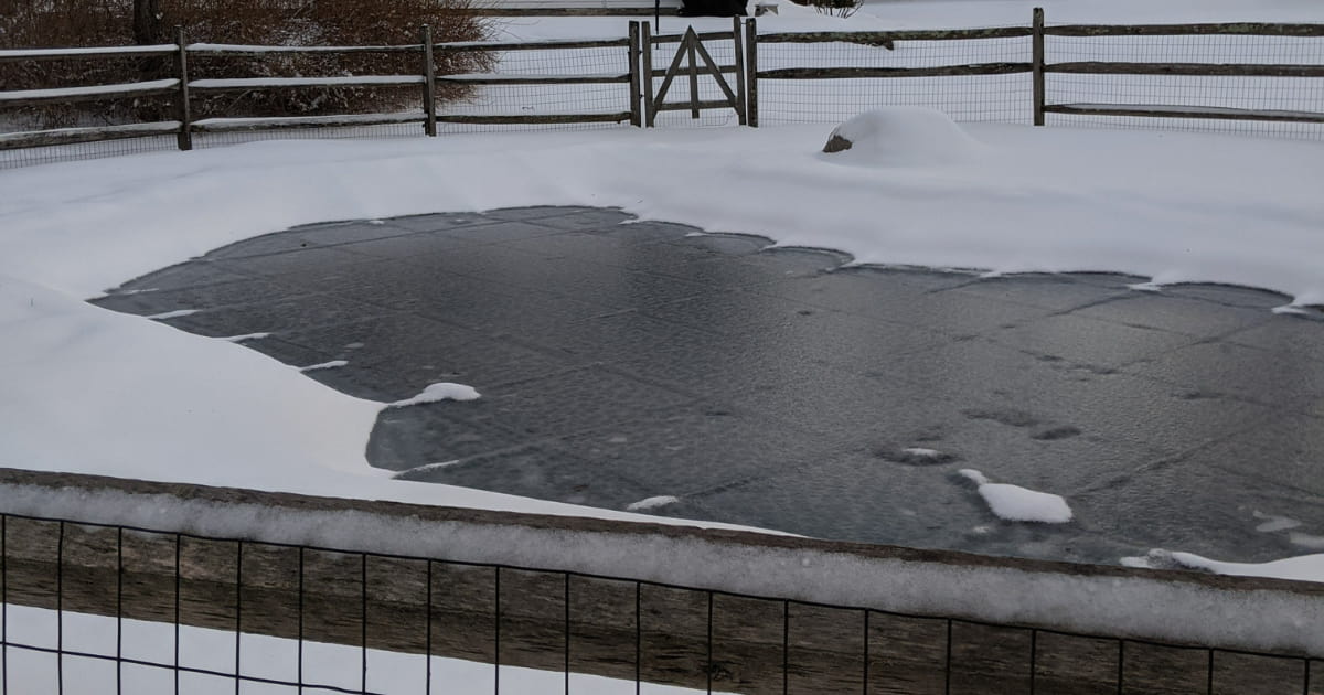 A swimming pool cover in snow